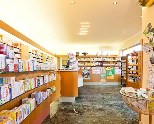 Offizin der Apotheke zum goldenen Kreuz mit Warenregalen und Beratungstheke